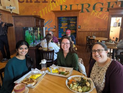 Niyati Dave, Heather Robinson, and Arielle Keller having lunch in a cafe